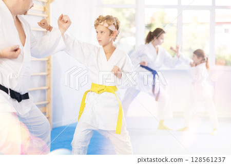 Father sparring with preteen son during martial arts training session Father sparring with preteen son during martial arts training session 128561237