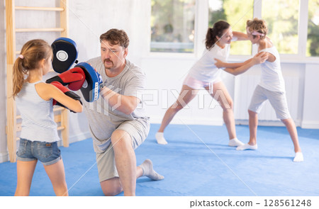 Father and daughter training boxing in studio Father and daughter training boxing in studio 128561248
