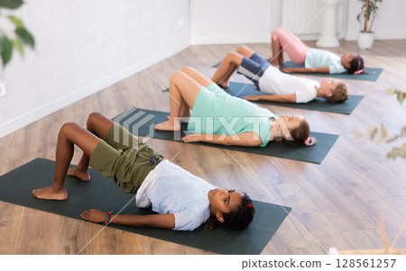 Kids yoga exercise - setu bandha sarvangasana. 128561257