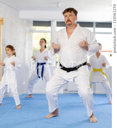 Family with children training karate techniques 128561259