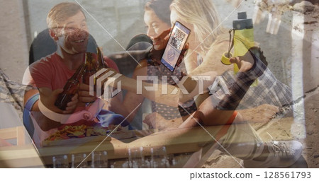 Image of man holding smartphone with covid 19 vaccination passport over people having fun 128561793