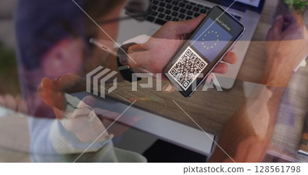 Image of man holding smartphone with covid 19 vaccination passport over payment terminal 128561798