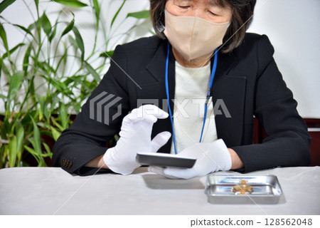 Image of an appraiser evaluating a watch Image of an appraiser evaluating a watch 128562048