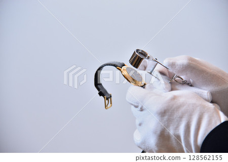 評估師正在評估一隻手錶的圖片 評估師正在評估一隻手錶的圖片 128562155