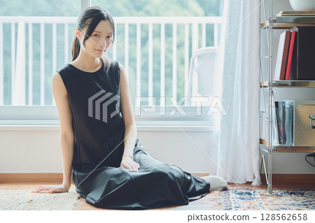 A woman sitting on the window side A woman sitting on the window side 128562658