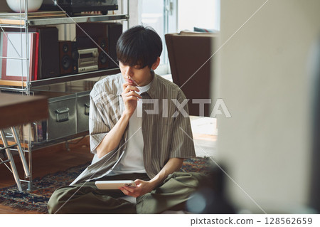 A man pondering in a room 128562659