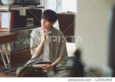 A man pondering in a room A man pondering in a room 128562660