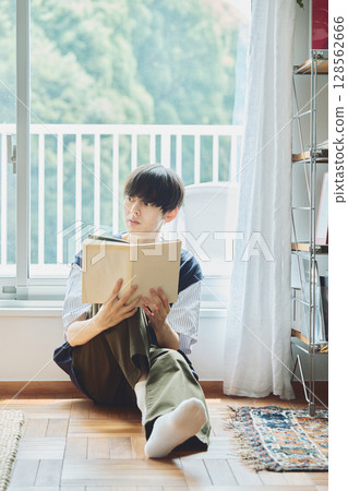 Man reading by the window Man reading by the window 128562666