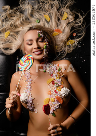 Woman adorned with vibrant candy body art in a beauty studio setting Woman adorned with vibrant candy body art in a beauty studio setting 128562673