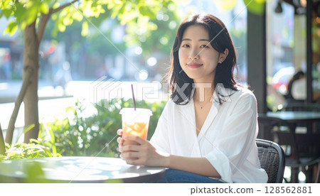 A woman relaxing at an open cafe 128562881