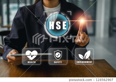 Businesswoman interacting with HSE digital interface emphasizing health, safety, and environment in the workplace. 128562907