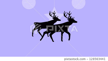Black silhouette of two reindeers walking over christmas hanging decorations on purple background 128563441