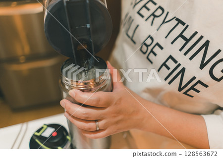 A housewife pouring barley tea into a water bottle A housewife pouring barley tea into a water bottle 128563672