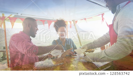 Composite of happy african american couple buying takeaway food, and mountain countryside Composite of happy african american couple buying takeaway food, and mountain countryside 128563742