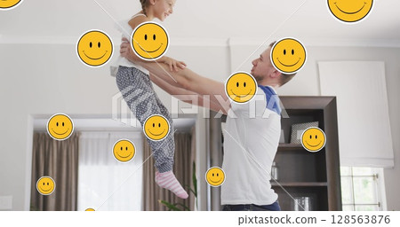 Image of smiley faces over happy caucasian father and daughter jumping at home Image of smiley faces over happy caucasian father and daughter jumping at home 128563876