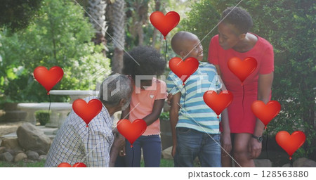 Image oh heart balloons over happy african american family in garden 128563880