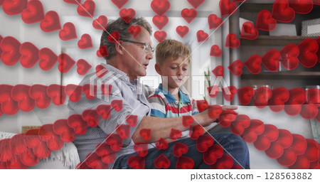 Image of hearts over happy caucasian grandfather and grandson using tablet on sofa Image of hearts over happy caucasian grandfather and grandson using tablet on sofa 128563882