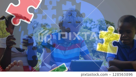 Image of colourful puzzle pieces and human head over children using tablets 128563896