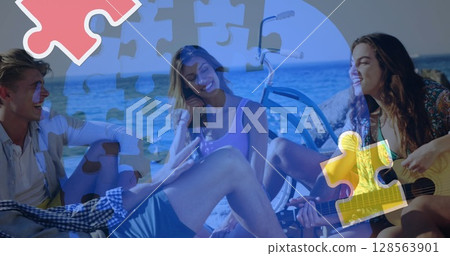 Image of colourful puzzle pieces and human head over happy friends at summer beach party 128563901