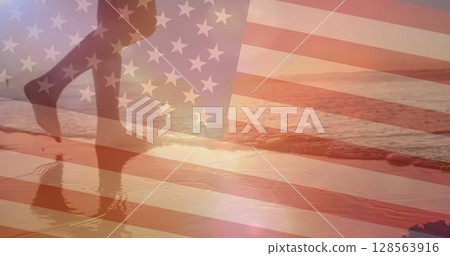 Image of flag of united states of america over woman walking on beach 128563916