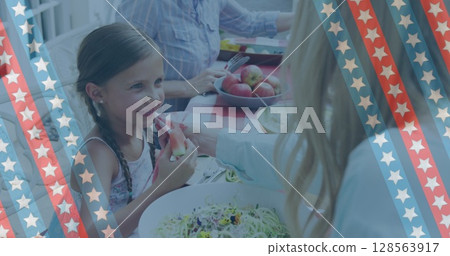 Image of stripes with stars over caucasian mother and daughter eating in garden 128563917