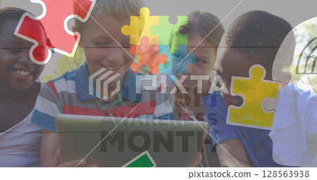 Image of colourful puzzle pieces and autism text over children using tablet 128563938