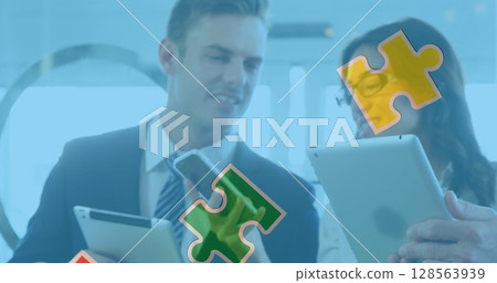 Image of colourful puzzle pieces over business people using digital devices Image of colourful puzzle pieces over business people using digital devices 128563939