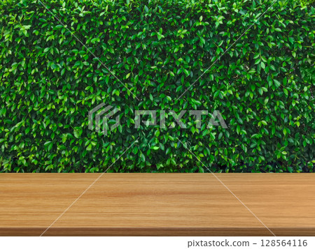 Empty wooden table, green bush background. Empty wooden table, green bush background. 128564116