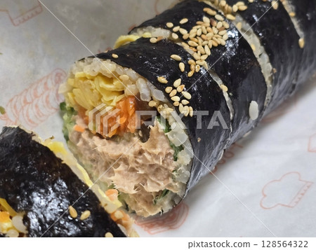 Delicious kimbap rolls filled with fresh vegetables, seasoned rice, and savory proteins, all wrapped in crisp seaweed. A perfect combination of flavor and texture in every bite. 128564322