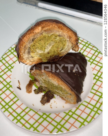 A croissant is a classic French pastry known for its buttery, flaky layers and golden crust. Often enjoyed plain or filled with chocolate, almond, or ham and cheese. 128564346