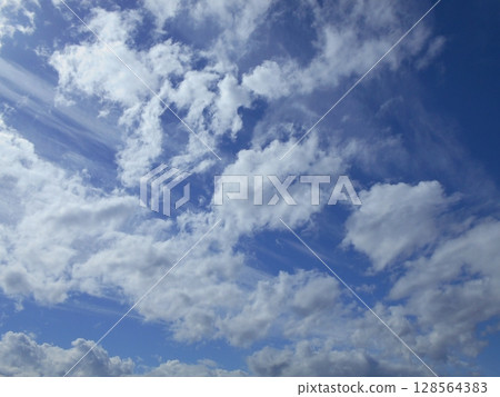 White clouds moving through the blue sky White clouds moving through the blue sky 128564383