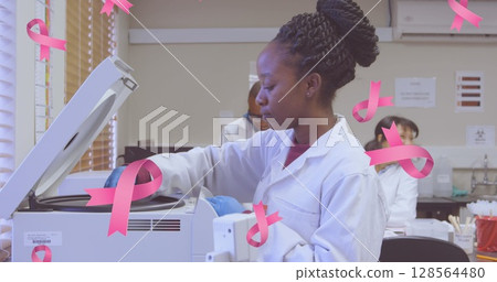 Image of pink breast cancer ribbons falling over group of working doctors 128564480