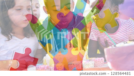 Image of colourful puzzle pieces hand over children with birthday cake at party 128564481