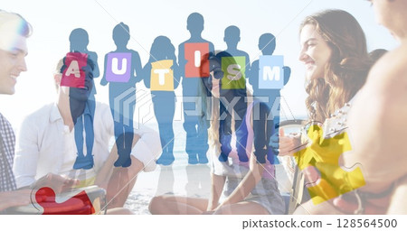 Image of colourful puzzle pieces and autism text over happy friends at summer beach party 128564500