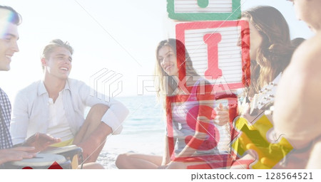 Image of colourful puzzle pieces and autism text over happy friends at summer beach party 128564521