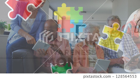 Image of colourful puzzle pieces and autism text over senior friends using tablets 128564553