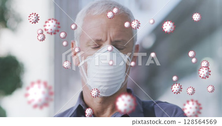 Image of covid 19 cells over senior man wearing face mask 128564569