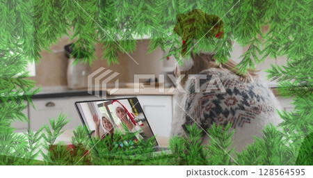 Green branches over caucasian woman wearing santa hat having a imagecall on laptop during christmas Green branches over caucasian woman wearing santa hat having a imagecall on laptop during christmas 128564595