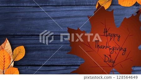 Happy thanksgiving day text over autumn maple leaf against blue wooden background 128564649