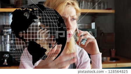 Image of globe spinning over woman using smartphone 128564825