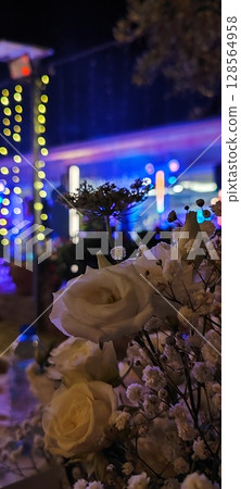 Rustic floral arrangement in jars. Festive decoration, white roses and plant branches in decorative jars. 128564958