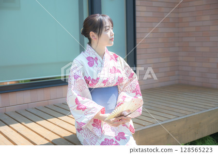 Woman in yukata with folding fan 128565223