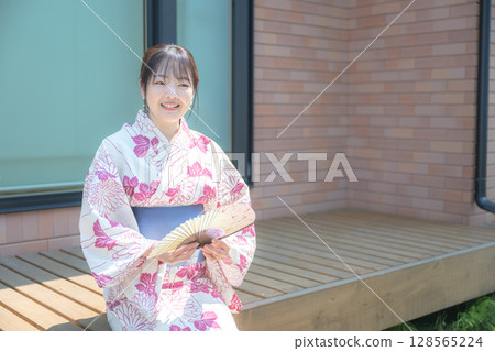 Woman in yukata and folding fan 128565224