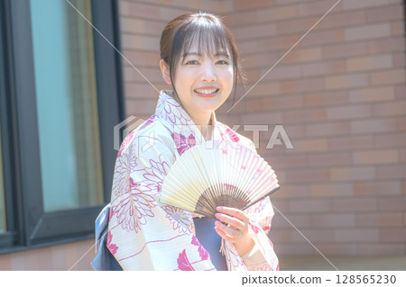 A stylish and smiling yukata woman 128565230