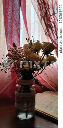 Still life of roses in vintage mason jar. Still life with book, coffee, and flowers. 128565621