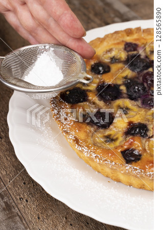 Cutting the baked fruit tart Cutting the baked fruit tart 128565890