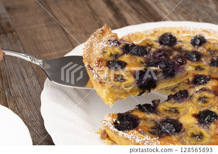 Cutting the baked fruit tart Cutting the baked fruit tart 128565893