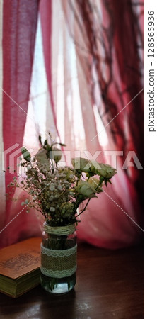 Still life of roses in vintage mason jar. Still life with book, coffee, and flowers. 128565936