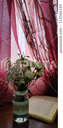 Still life of roses in vintage mason jar. Still life with book, coffee, and flowers. 128566194