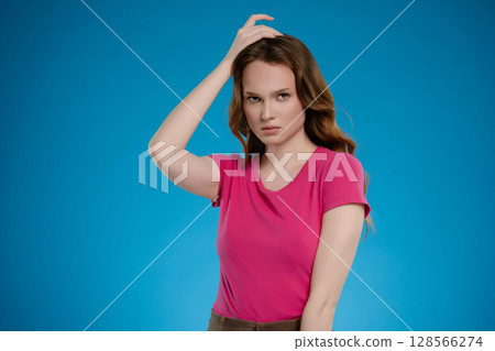 Woman posing in a studio setting expressing various emotions against a vibrant blue background 128566274
